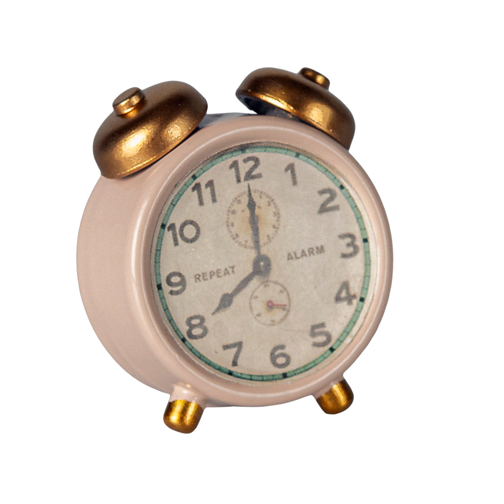 Close-up of the Maileg alarm clock in powder pink with gold bells and a vintage-style clock face.