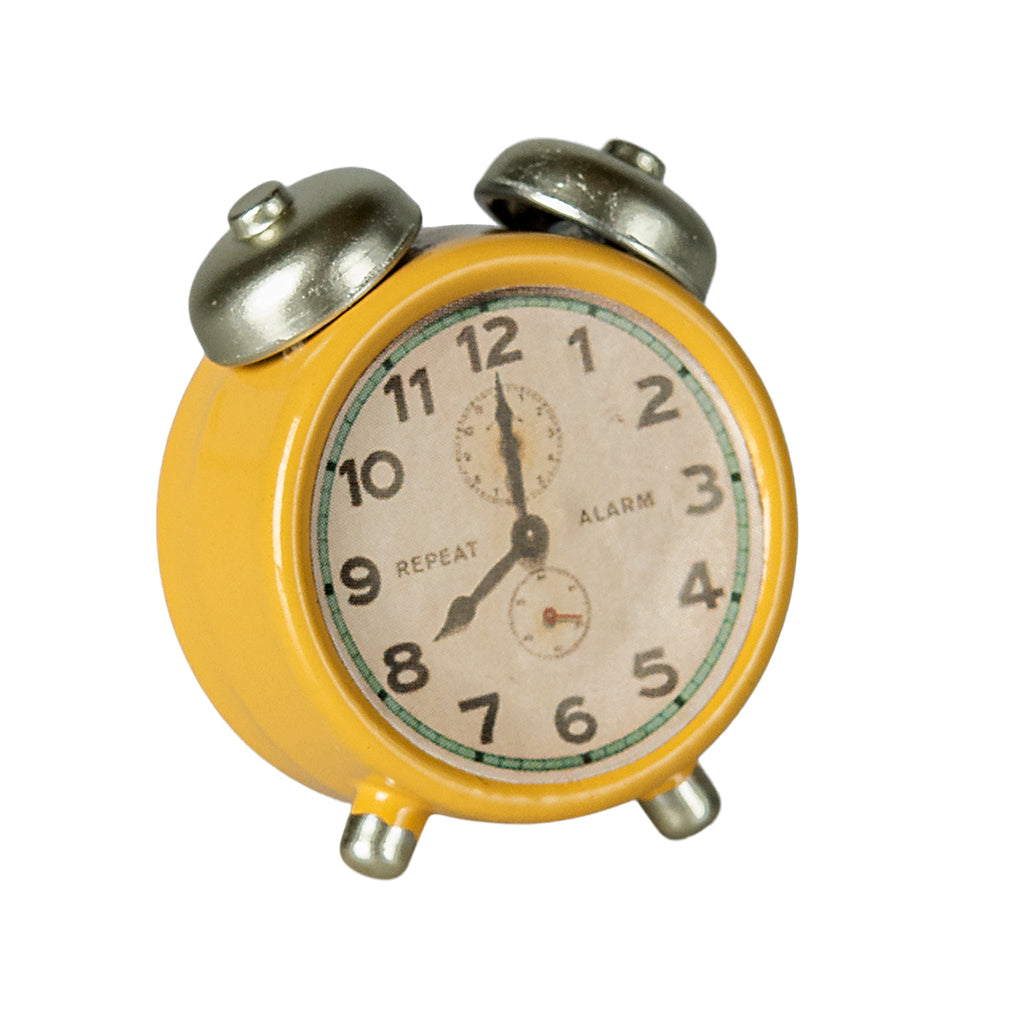 Close-up of the Maileg alarm clock in yellow with silver bells and a classic clock face.