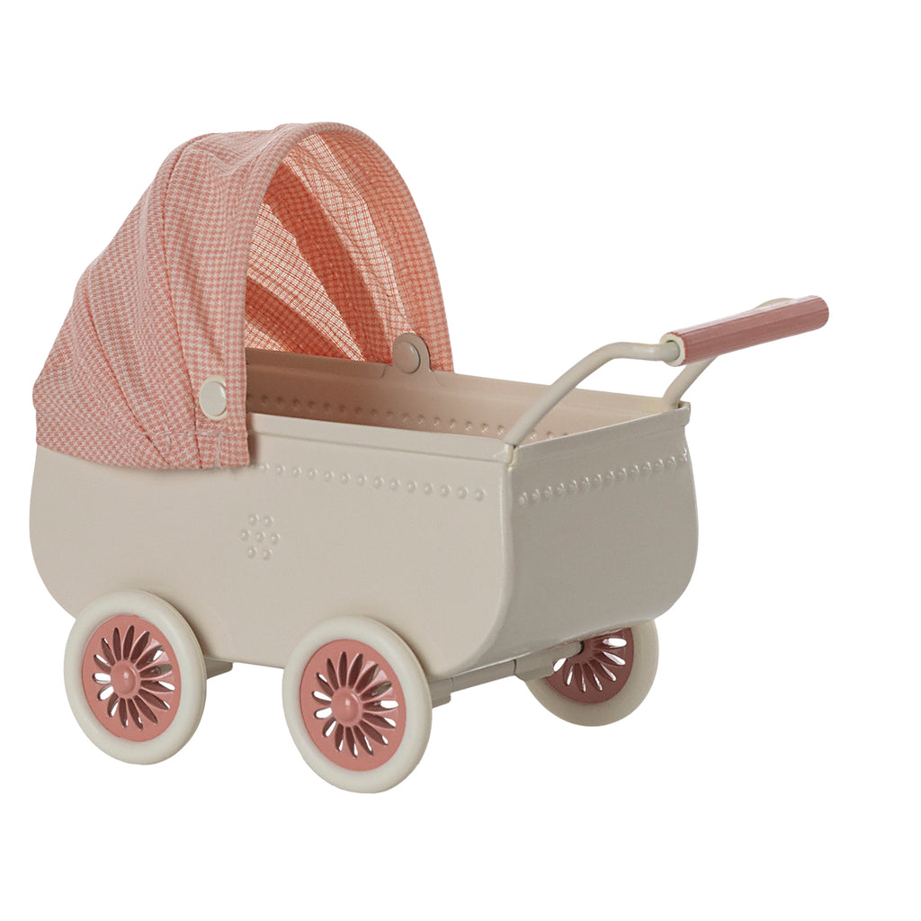 Rear view of Maileg pram in coral pink, showcasing its pink floral wheels and sturdy handle.