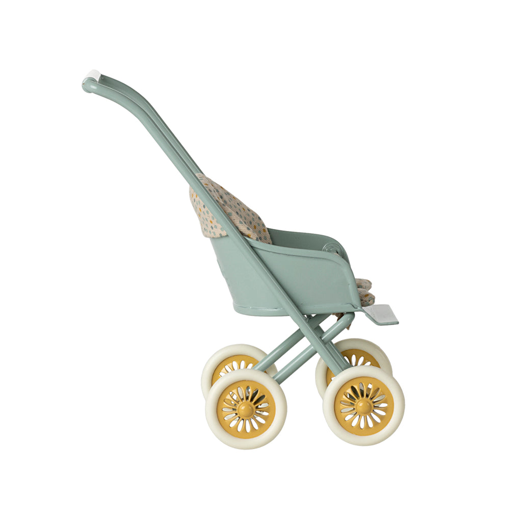 A side-facing view of the Maileg micro stroller in mint, showcasing its vintage-inspired design with a floral seat and yellow-accented wheels.