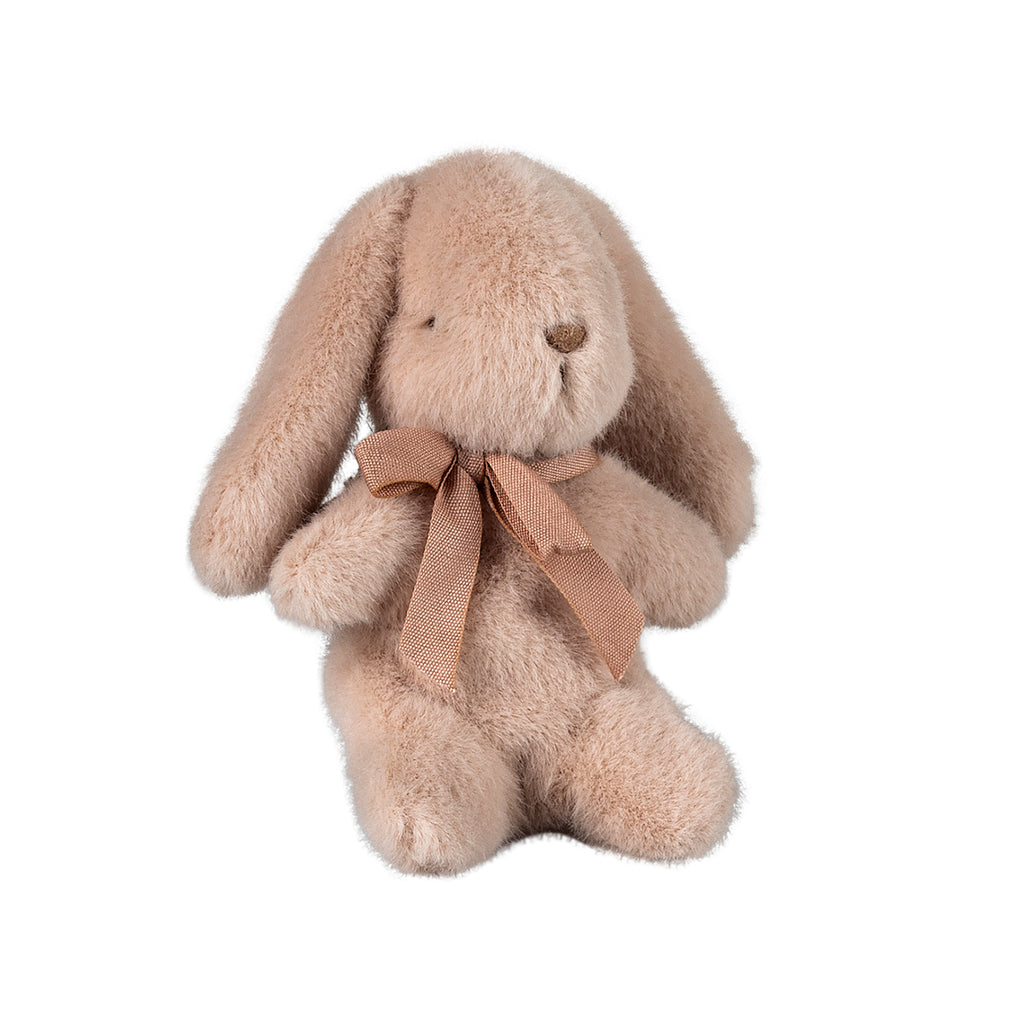 A sweet mini Maileg bunny in a soft light powder colour, sitting gracefully with a charming pink bow tied around its neck.