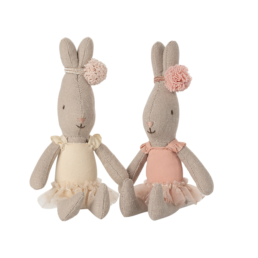 Two adorable Maileg micro ballet rabbits sitting side by side; one is wearing a rose ballet suit, and the other is dressed in a cream ballet suit, both looking elegant and ready for the stage