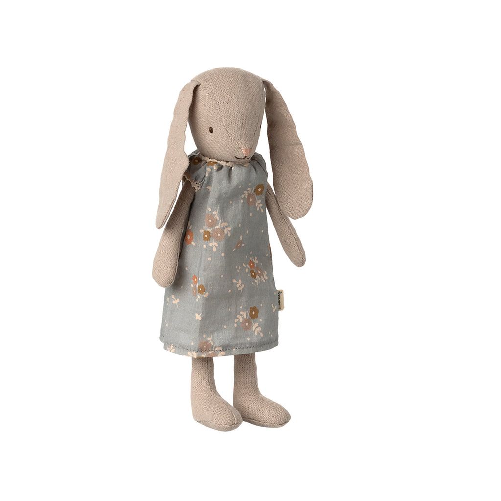 A soft Maileg bunny wearing a charming grey dress adorned with delicate floral patterns.