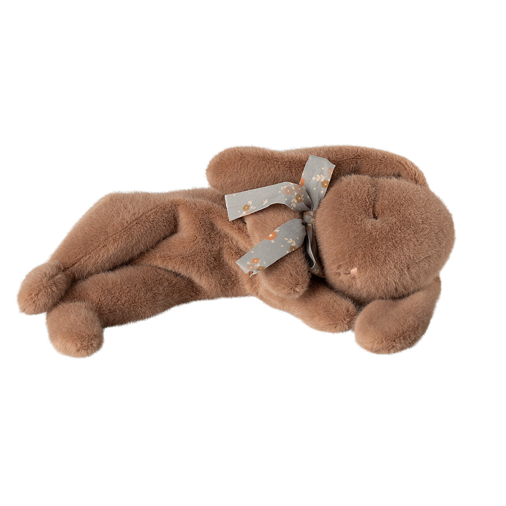 Maileg sleeping bunny plush in soft brown, lying on its side with a floral-patterned bow around its neck.