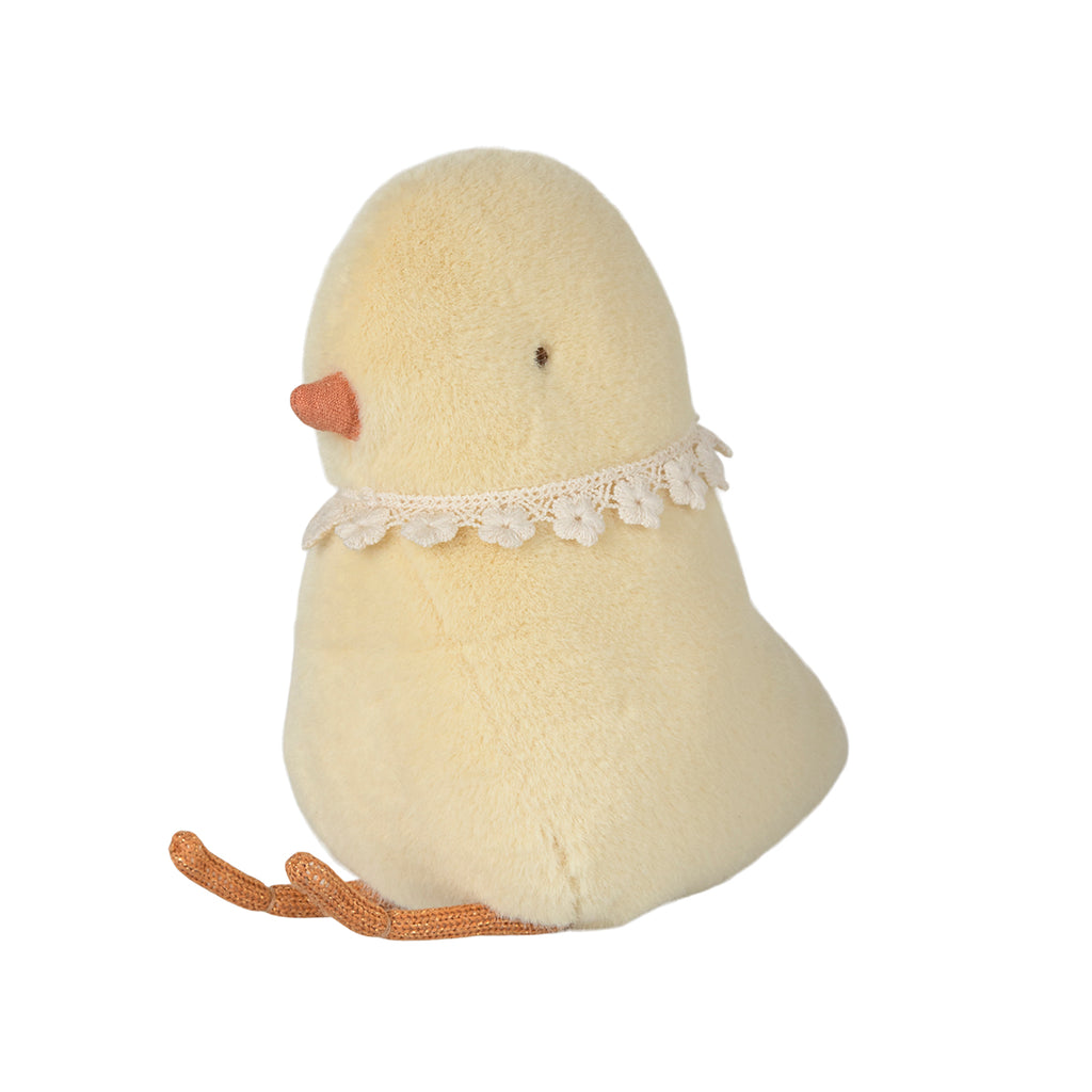 Side view of a yellow Maileg chick plush featuring a delicate lace collar and tiny orange beak.