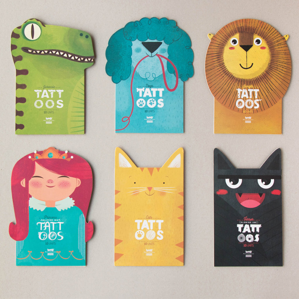 Set of six Londji temporary tattoo packs, each with a unique illustrated character-shaped design, including a green dinosaur, blue poodle, lion, red-haired princess, orange tabby cat, and black vampire cat, arranged on a neutral background.