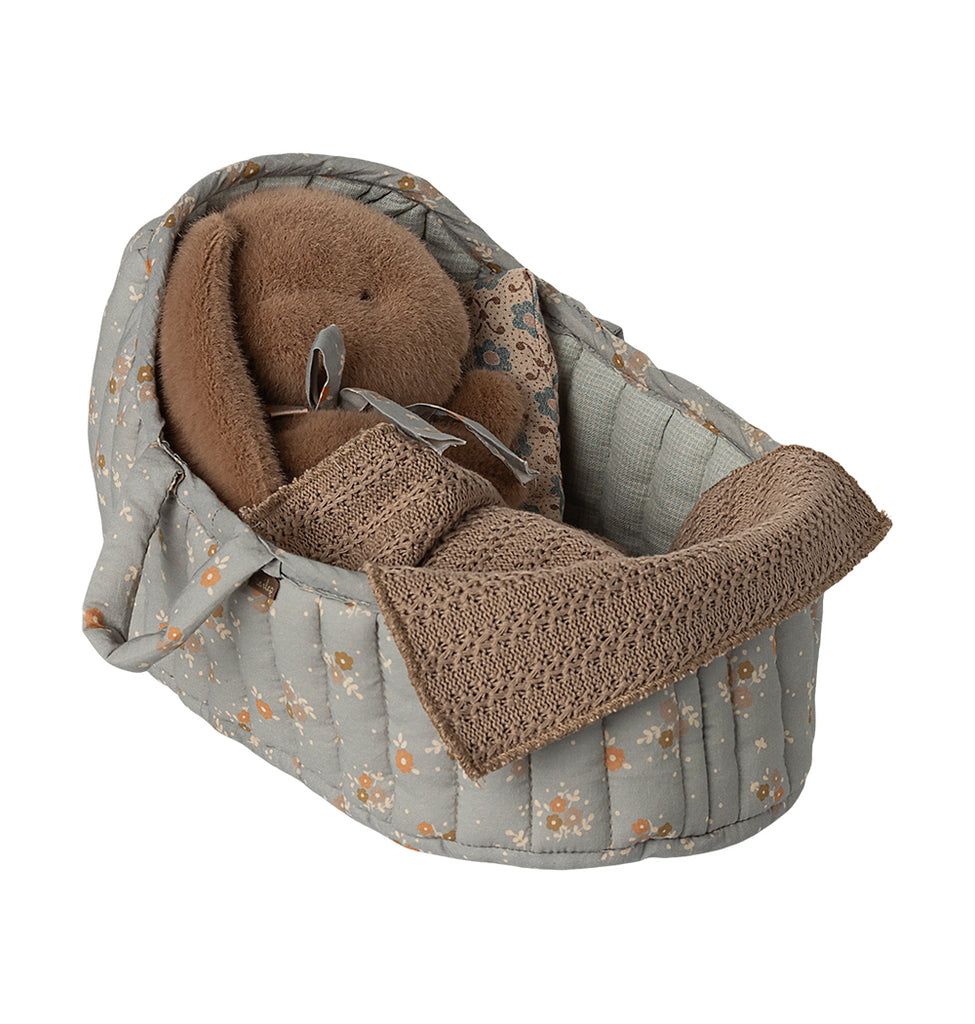 Maileg large carry cot in blue with floral quilted lining, holding a bunny wrapped in a knitted blanket