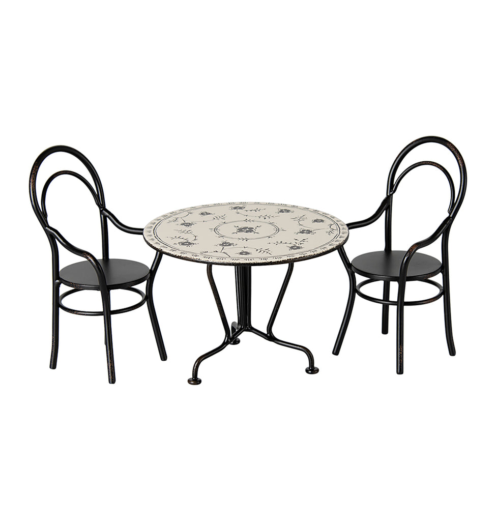 Maileg miniature dining table set with a floral-patterned metal table and two black metal chairs