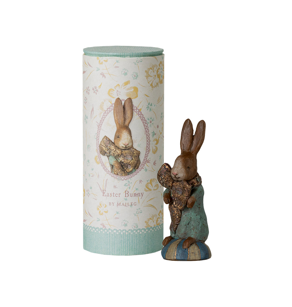 Maileg Easter Bunny figurine holding a gold-accented ribbon, standing on a striped pedestal