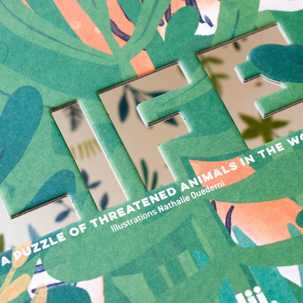 Cut-out "LIFE" text on the puzzle box with jungle-themed illustrations.