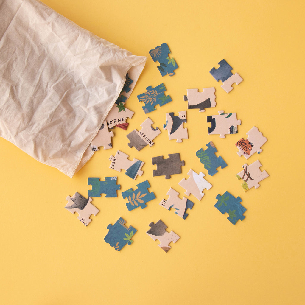 Cotton storage bag spilling out puzzle pieces with illustrations of endangered animals.