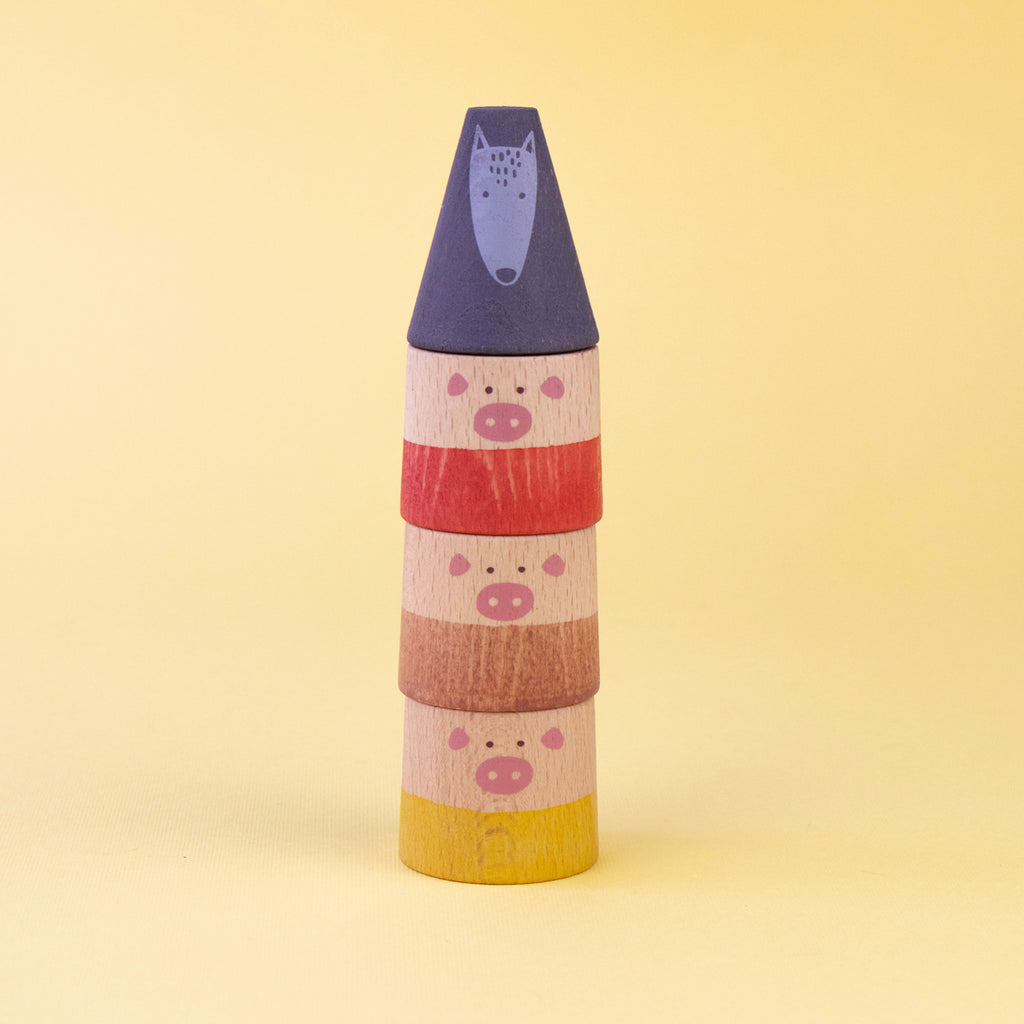 Stacked pig characters with the wolf figure balanced on top in the My Three Little Pigs game