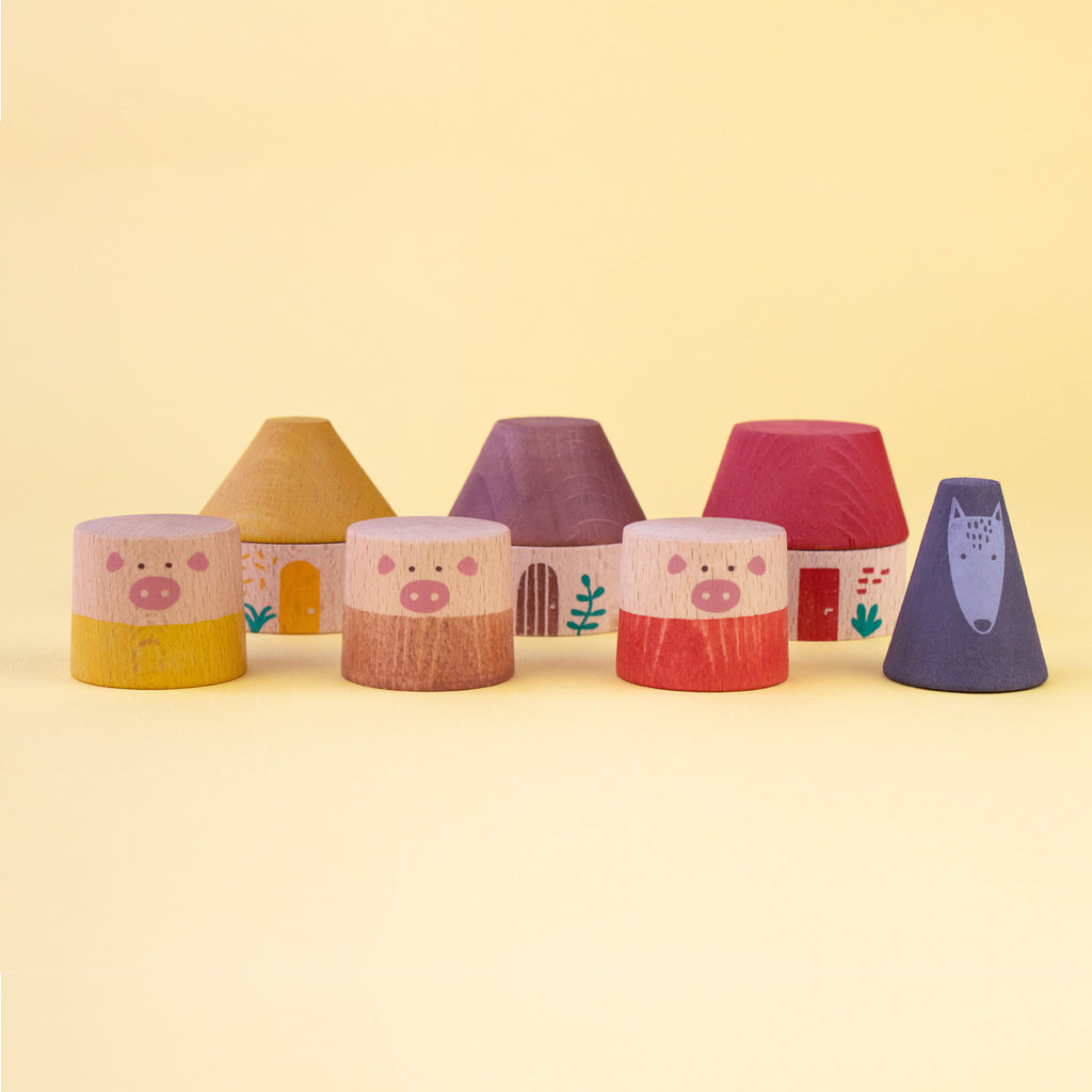 Set of wooden pig characters and houses from the Londji My Three Little Pigs stacking game.