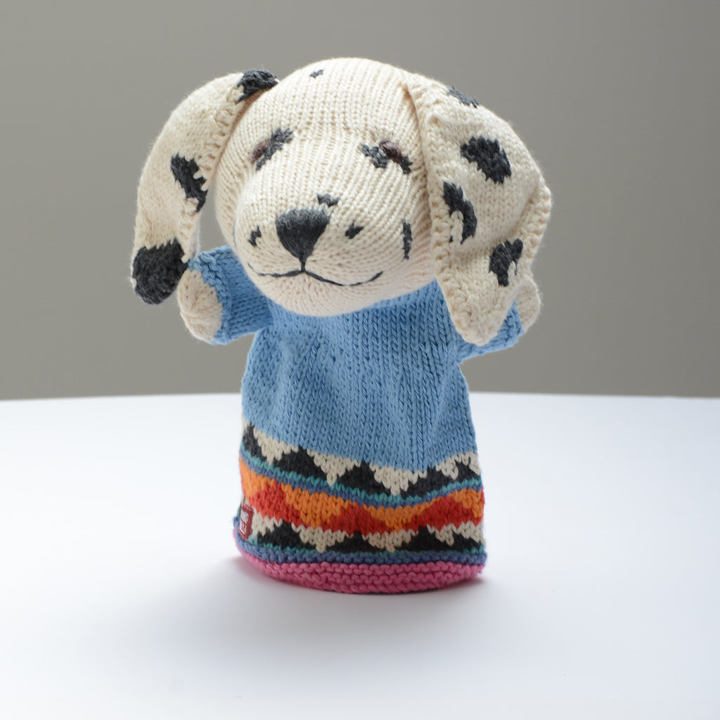  A knitted hand puppet by ChunkiChilli featuring a cheerful Dalmatian with floppy ears, wearing a blue jumper and a colourful patterned base, displayed on a white background.